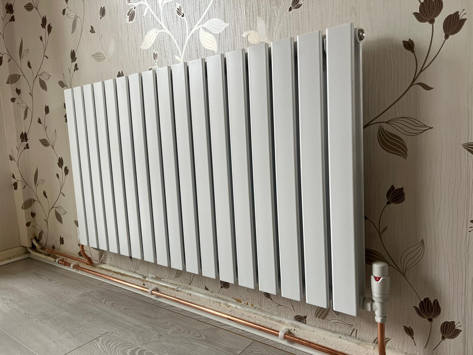 Modern flat panel radiator with thermostatic valve for energy-efficient heating